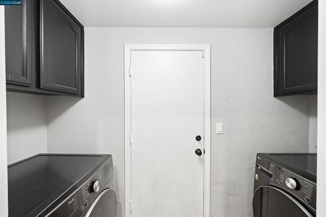 washroom featuring cabinets and washer and clothes dryer