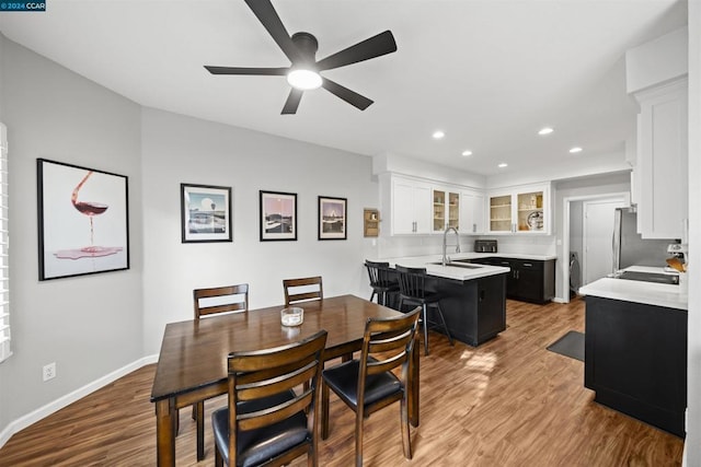 dining room with ceiling fan, sink, and hardwood / wood-style flooring