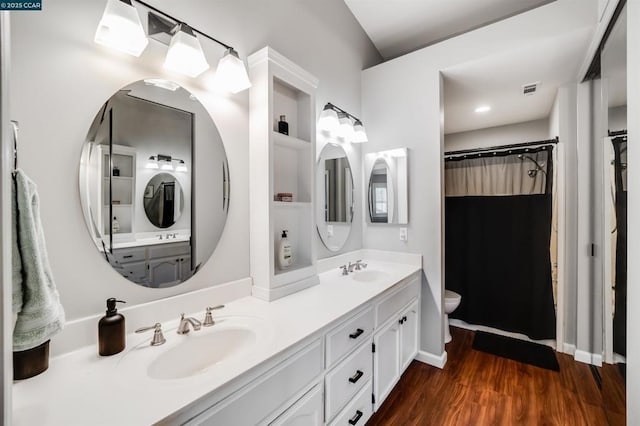 bathroom featuring toilet, vanity, and hardwood / wood-style flooring