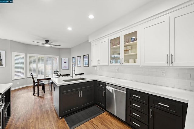 kitchen with ceiling fan, stainless steel dishwasher, kitchen peninsula, sink, and white cabinets