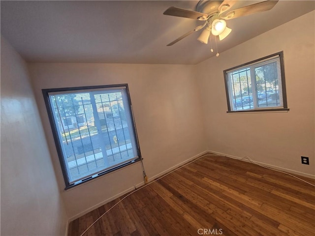 unfurnished room featuring a wealth of natural light, dark wood-type flooring, and ceiling fan