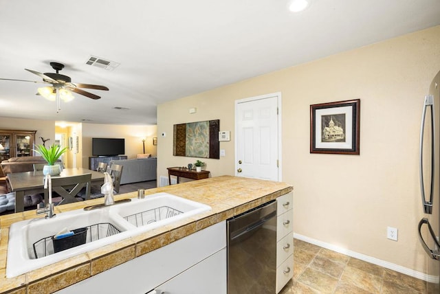 kitchen with stainless steel refrigerator, ceiling fan, dishwasher, sink, and white cabinets