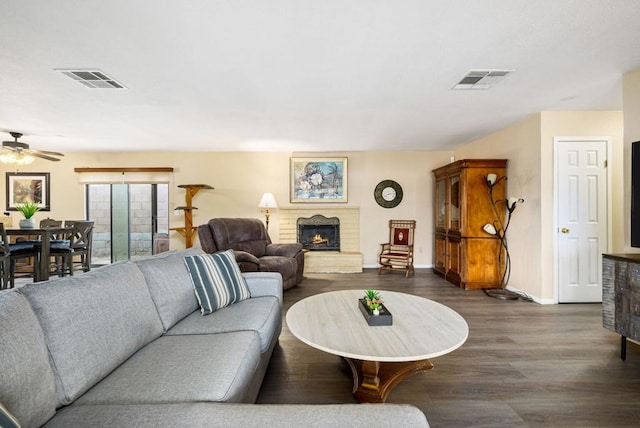 living room with ceiling fan, a fireplace, and dark hardwood / wood-style floors