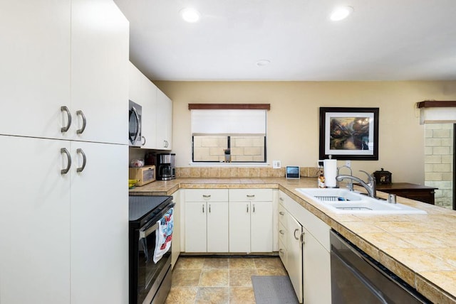 kitchen with white cabinets, stainless steel appliances, kitchen peninsula, and sink