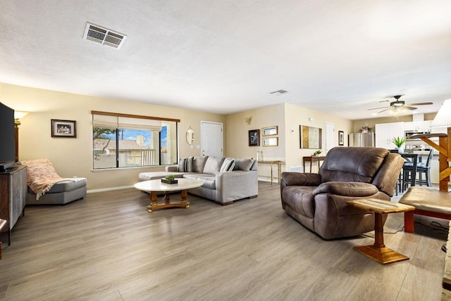 living room with light wood-type flooring and ceiling fan