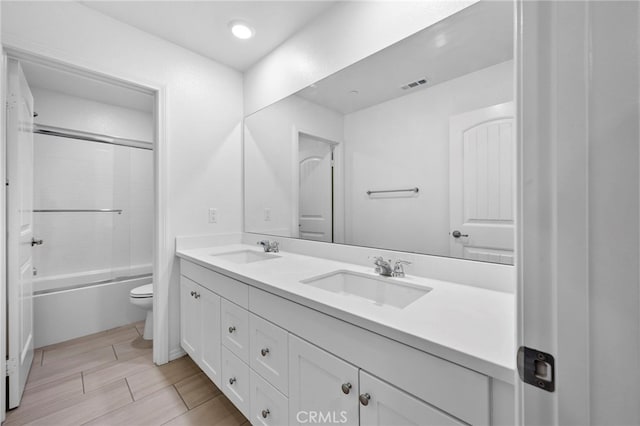 full bathroom with vanity, toilet, and bath / shower combo with glass door