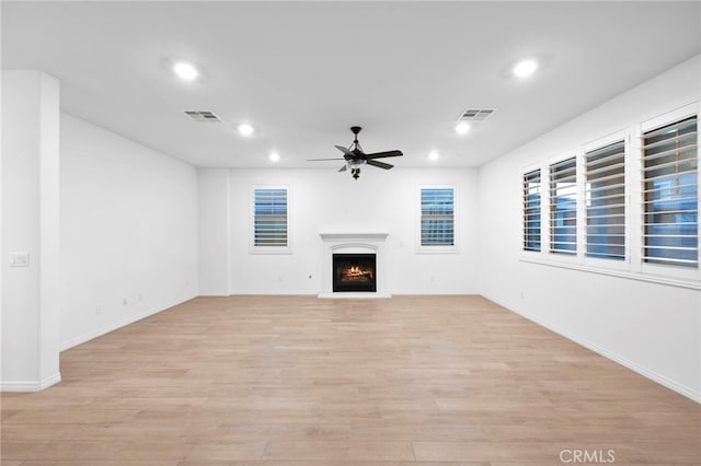 unfurnished living room with light hardwood / wood-style flooring and ceiling fan