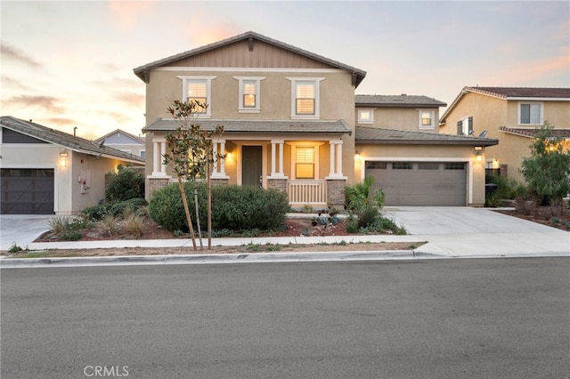 5418 Heitz Way, Fontana, CA 92336 - view of front of house featuring concrete driveway, a garage, a porch, and stucco siding