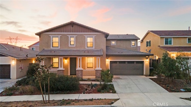 5418 Heitz Way, Fontana, CA 92336 - traditional-style house with covered porch, a garage, concrete driveway, brick siding, and stucco siding