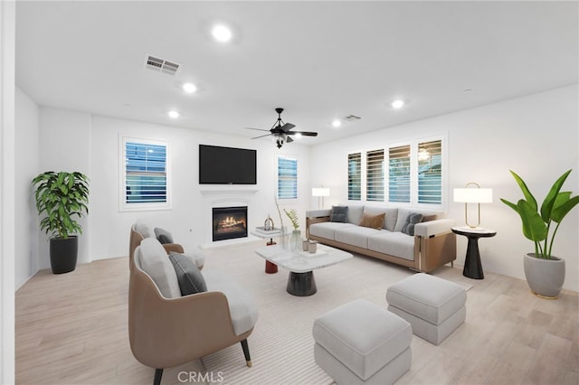 living room with light hardwood / wood-style flooring and ceiling fan