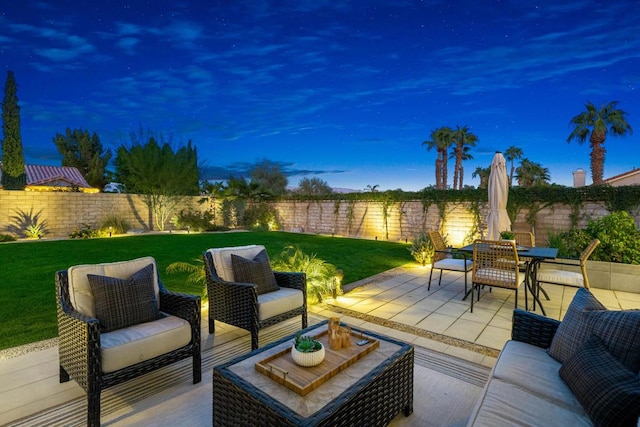 patio terrace at dusk featuring outdoor lounge area and a lawn