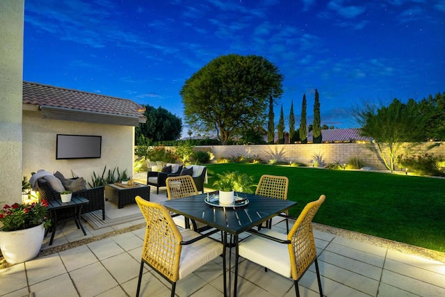 patio terrace at dusk with outdoor lounge area and a lawn