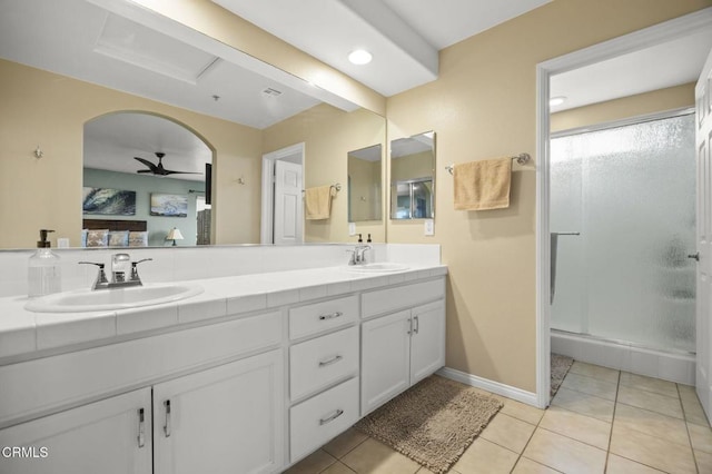 bathroom featuring tile patterned flooring, a shower stall, double vanity, and a sink