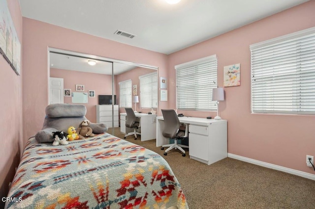 bedroom with baseboards, visible vents, a closet, and light carpet