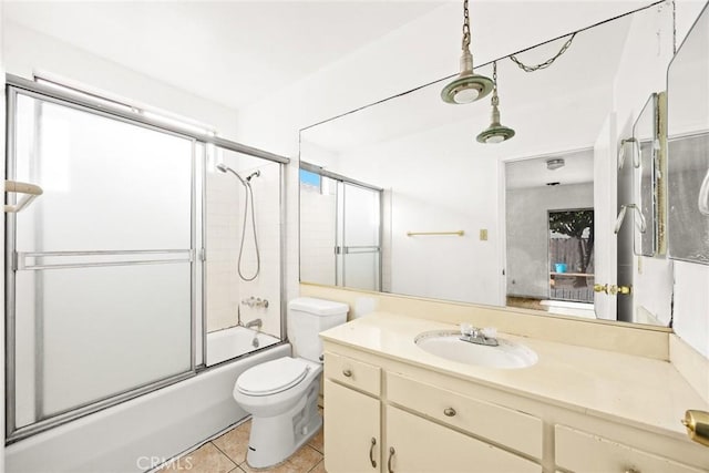 full bathroom featuring tile patterned flooring, vanity, toilet, and shower / bath combination with glass door