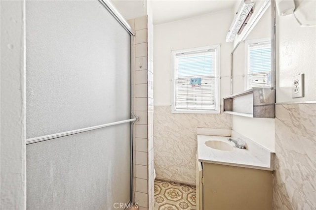 bathroom with vanity, tile walls, and a shower with shower door