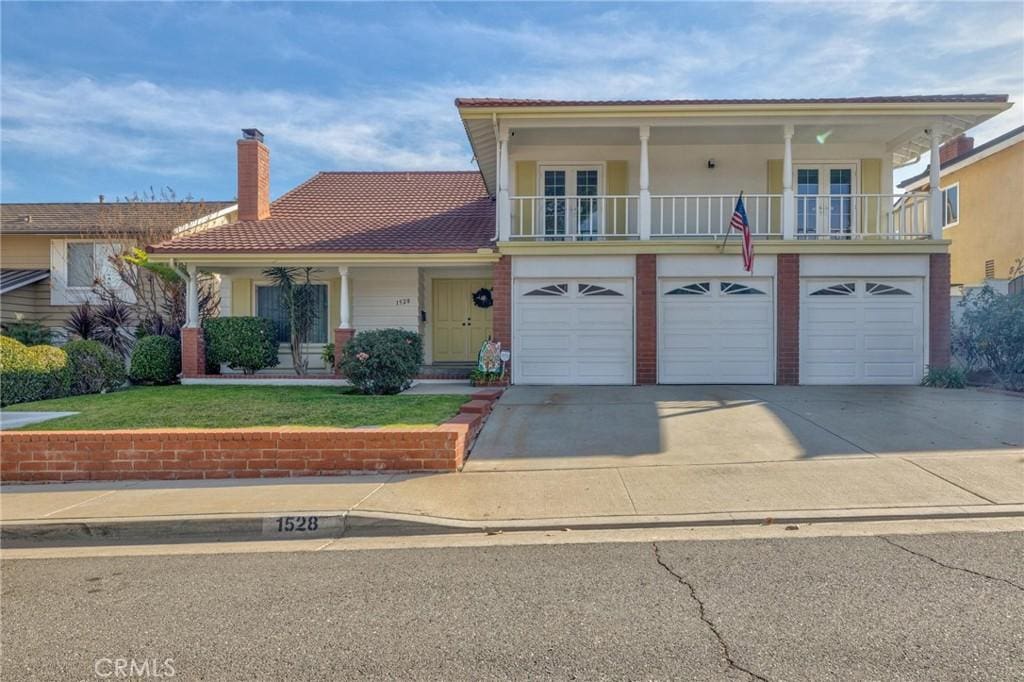 view of front of home featuring a garage, a front yard, and french doors