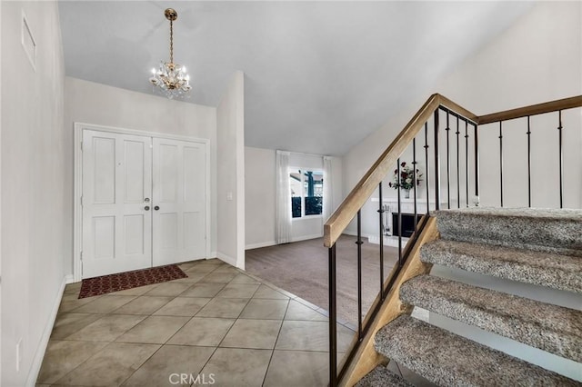 carpeted foyer entrance featuring a chandelier