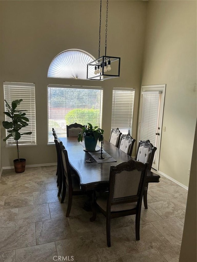 dining room with a high ceiling and an inviting chandelier