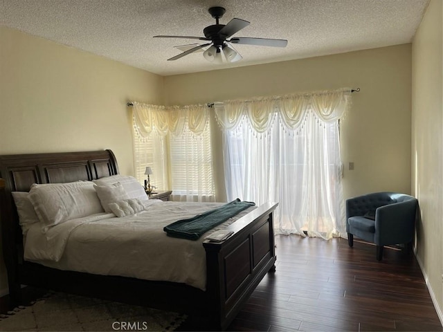 bedroom featuring a textured ceiling, ceiling fan, and dark hardwood / wood-style floors