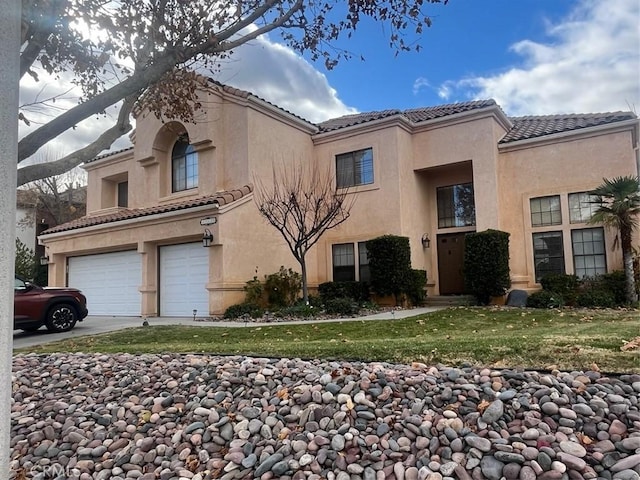 mediterranean / spanish-style house featuring a front lawn and a garage