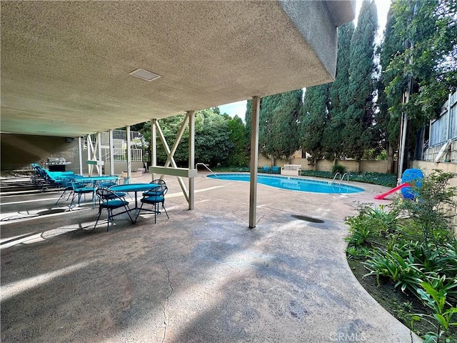 view of swimming pool featuring a patio area