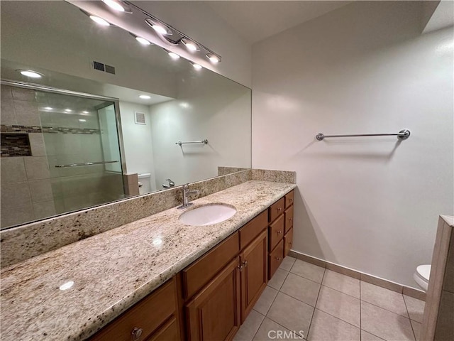 bathroom featuring tile patterned flooring, vanity, a shower with door, and toilet