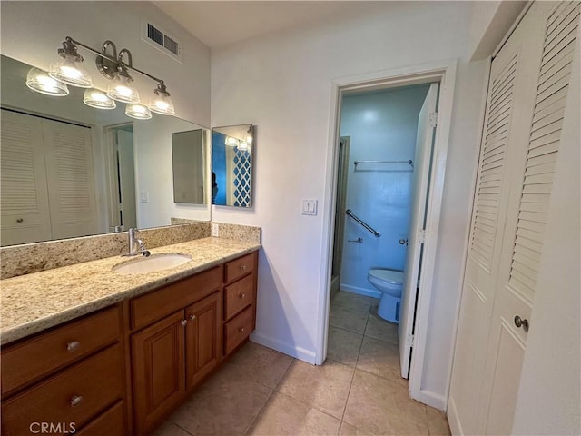 bathroom featuring vanity, tile patterned floors, and toilet