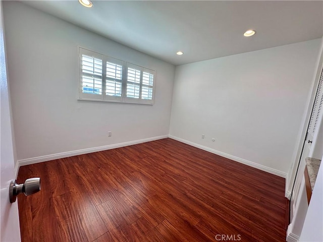 unfurnished room with dark wood-type flooring