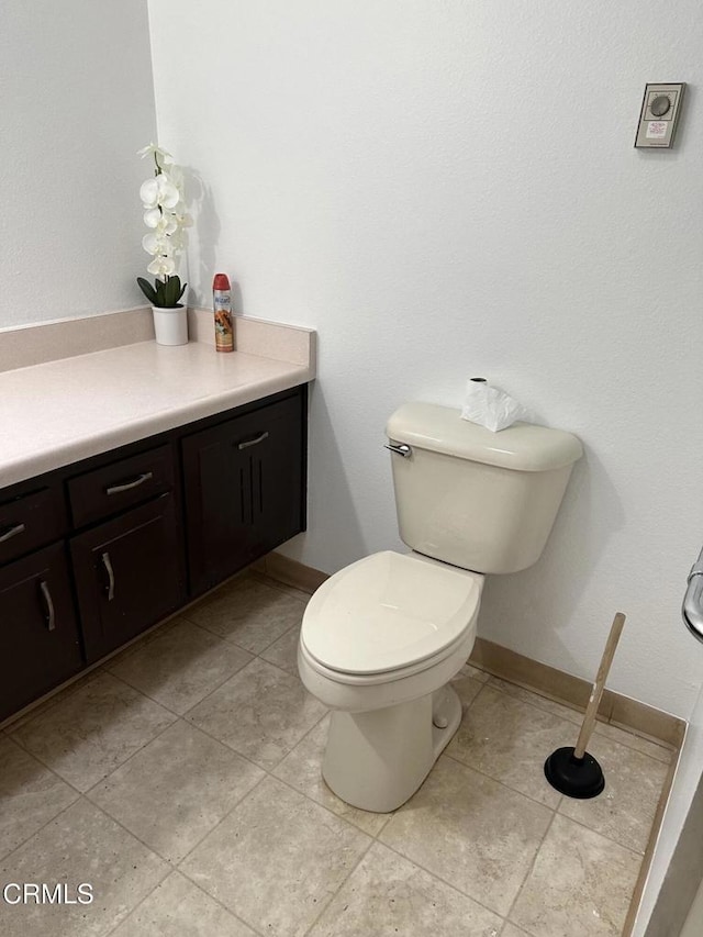 bathroom featuring tile patterned flooring, vanity, and toilet