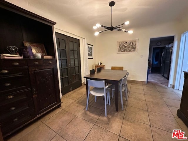 tiled dining room featuring a chandelier