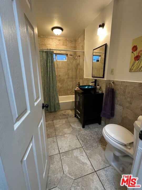 full bathroom with vanity, tile patterned flooring, toilet, tile walls, and shower / tub combo