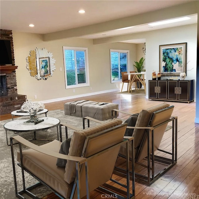 living room with wood-type flooring and a brick fireplace