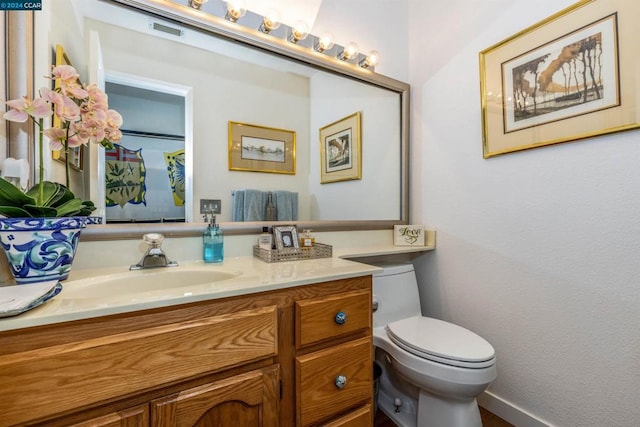 bathroom featuring vanity and toilet