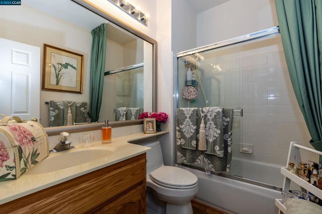 full bathroom with vanity, toilet, and enclosed tub / shower combo