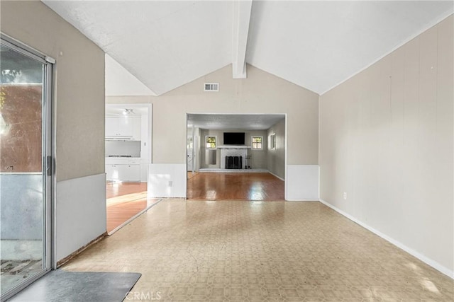 unfurnished living room featuring vaulted ceiling with beams