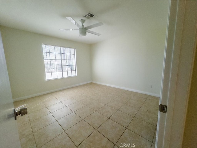 tiled empty room featuring ceiling fan