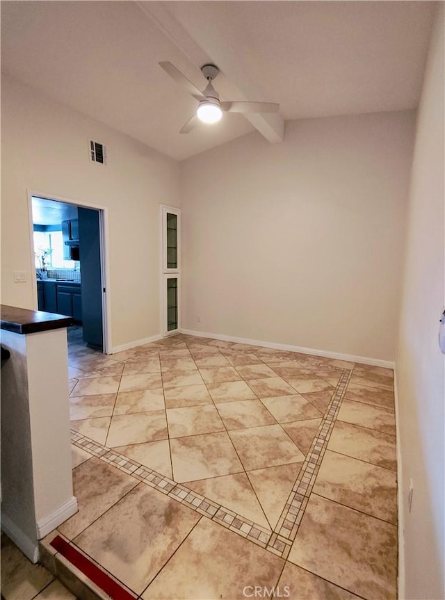 empty room featuring ceiling fan and vaulted ceiling with beams