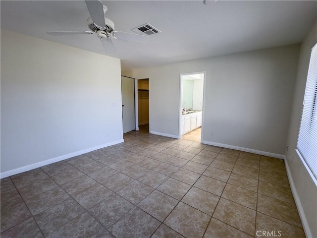 tiled empty room featuring ceiling fan