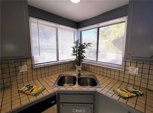 kitchen with decorative backsplash, sink, gray cabinetry, and tile countertops