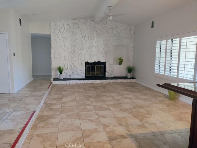 unfurnished living room featuring ceiling fan and a stone fireplace