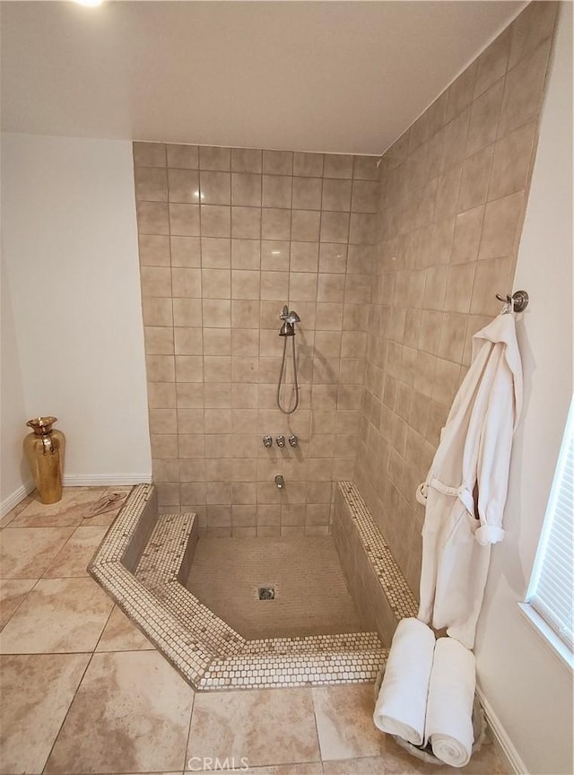 bathroom featuring tile patterned flooring and tiled shower