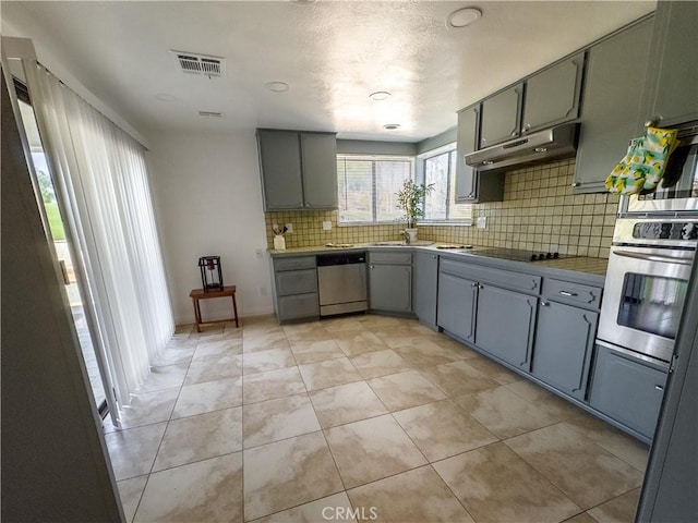 kitchen with decorative backsplash, light tile patterned floors, and appliances with stainless steel finishes