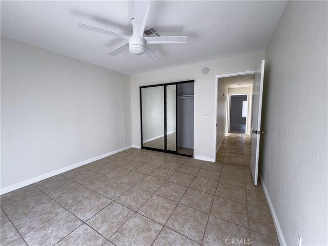 unfurnished bedroom with ceiling fan, light tile patterned floors, and a closet