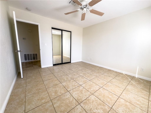 unfurnished bedroom with ceiling fan, light tile patterned flooring, and a closet