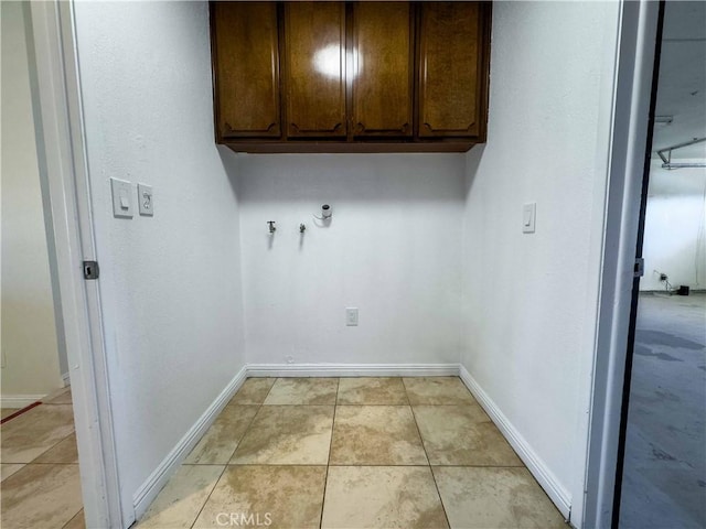 laundry room featuring washer hookup, cabinets, and light tile patterned floors