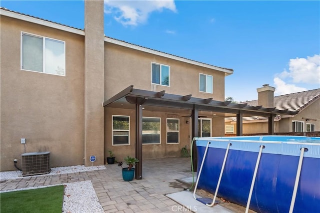 back of house with a patio area, a pergola, and central AC