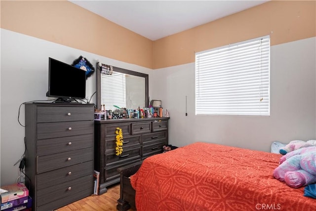 bedroom with multiple windows and light hardwood / wood-style flooring