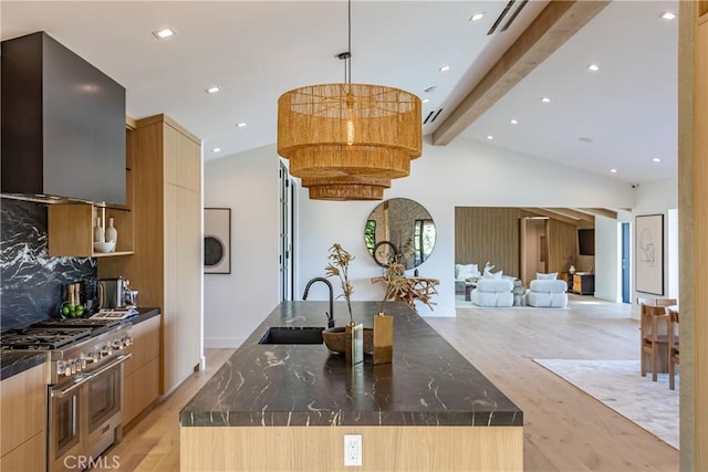 kitchen featuring sink, a spacious island, range with two ovens, and light hardwood / wood-style floors