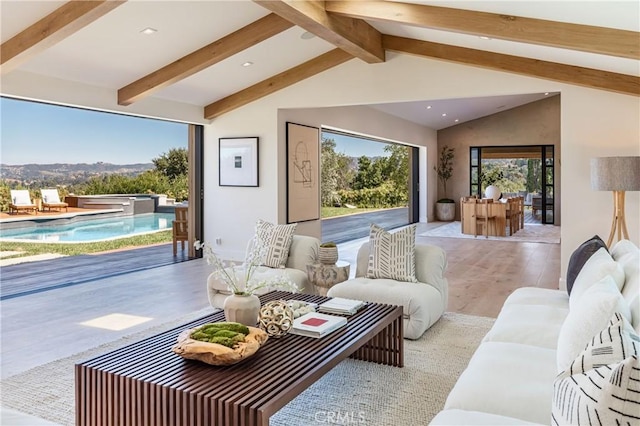 living room with lofted ceiling with beams and light hardwood / wood-style flooring